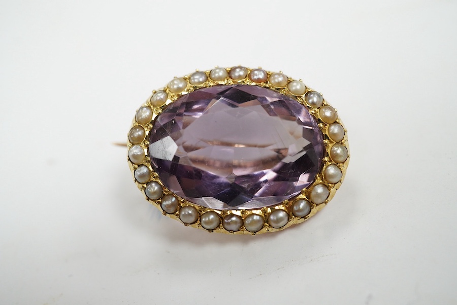 An Edwardian 15ct, amethyst and split pearl cluster set oval brooch, 23mm, gross weight 5 grams. Condition - good